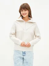 Sweater color crudo, de tejido de punto con cuello polo y cierre frontal parcial con cremallera.