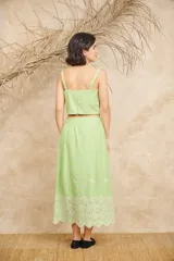 Conjunto de pollera midi y crop top celeste, con bordado de flores blancas.