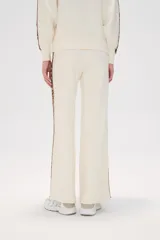 Pantalón de punto color crema, de corte ancho y tiro alto, con estampado animal print en los laterales.