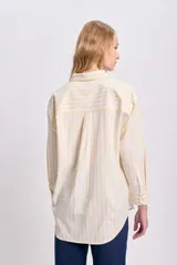 Camisa de manga larga con cuello clásico y bolsillo en el pecho, con estampado a rayas verticales amarillas y blancas.