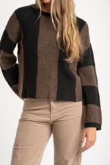 Sweater de tejido de punto grueso, con diseño de rayas verticales anchas en tonos marrón oscuro y negro. Presenta cuello redondo y mangas largas.