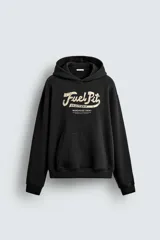 Sudadera negra con capucha, corte relaxed fit, confeccionada en tejido de algodón. Presenta un estampado frontal con la inscripción "Fuel Pit California Warehouse Crew".