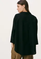 Camisa negra de corte holgado, con cuello clásico, cierre frontal con botones y mangas 3/4.