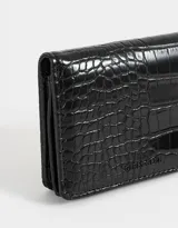 Billetera negra de cuerina con textura efecto croco y correa lateral.
