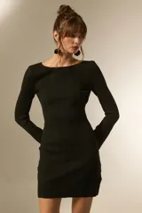 Vestido corto negro de tejido acanalado, manga larga y escote barco.