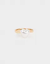 Anillo dorado con una perla blanca en forma de corazón.