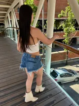 Short de jean azul con lavado claro, tiro alto y ruedo desflecado.