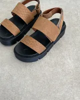 Sandalias con plataforma color marrón con textura de piel de reptil, con dos tiras anchas sobre el empeine y tira trasera ajustable.