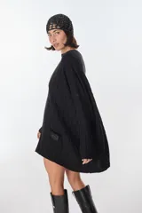 Sweater tejido artesanalmente en Uruguay, color beige con rayas verticales color camel y diseño de trenzas. Tiene bolsillos frontales y puños ajustados.
