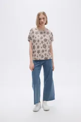 Remera blanca con estampado floral en color lila, de corte holgado y mangas cortas.