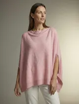 Poncho tejido de acrílico color rosa pálido, con cuello barco y aberturas laterales para los brazos. Presenta un dobladillo asimétrico con terminación acanalada.