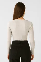 Remera de manga larga ajustada al cuerpo, color gris claro melange, con escote cuadrado.