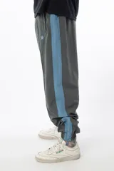 Pantalón de jogging gris con forro interno de red, bolsillos laterales con cierre, cierres en los tobillos y logo bordado.