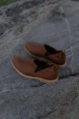 Mocasines marrones de cuero con elásticos laterales y tirador trasero.