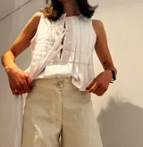 Musculosa blanca con cuello redondo, corte holgado y detalle de lazos en el frente.