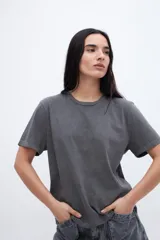 Remera gris de algodón con cuello redondo y mangas cortas. Diseño liso con efecto gastado.