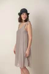 Vestido corto negro de seda con breteles finos anudados en los hombros y escote en V.