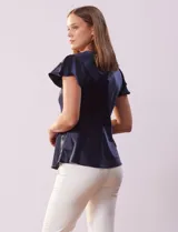 Blusa plateada de satén con manga corta amplia, corte bajo el busto y abertura con botón en la espalda.