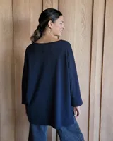 Remerón beige con manga larga negra y costuras blancas en los puños.