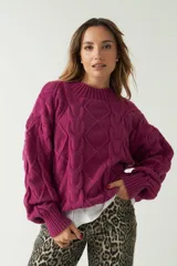 Sweater marrón de punto trenzado con cuello redondo y mangas largas abullonadas.