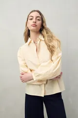 Camisa blanca de mangas 3/4 abullonadas con bordado floral en el frente.