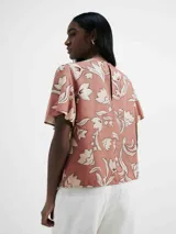 Blusa de manga corta con estampado floral en tonos rosados y blancos.