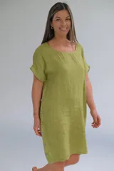 Vestido corto color verde pistacho, de lino italiano, corte suelto, escote redondeado, mangas cortas y botones decorativos en los costados.