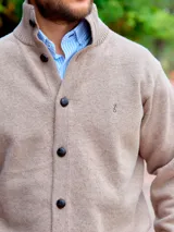 Saco de hombre color beige de lana con cuello alto y cierre frontal con botones.