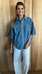 Sobrecamisa celeste de denim soft, con cuello camisero, mangas cortas y cierre frontal con botones. Tiene dos bolsillos con solapa en el pecho.