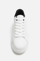 Zapatillas deportivas negras con detalle en blanco en la parte posterior y suela blanca con volumen de diseño irregular.