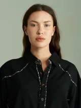 Camisa celeste de algodón con corte clásico y caída suelta. Presenta vivos en cuadrillé trazados en puños, canesú de la espalda y al pie del cuello.