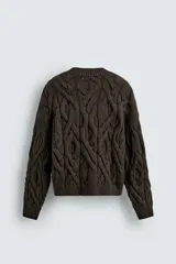 Sweater marrón oscuro de punto con estructura de trenzas, cuello redondo, manga larga y corte regular fit.