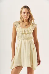 Vestido corto color crema con textura brillante, escote redondo con volados y cintura elastizada.