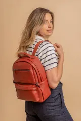 Mochila color marrón de símil cuero con un compartimento principal amplio, bolsillo al frente con cierre, correas ajustables y asa.