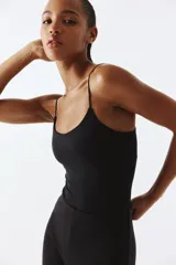 Pantalón negro de punto suave, tiro alto, cintura elástica y piernas amplias.