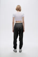 Pantalón de jogging color celeste con cintura elástica ajustable con cordón y puños elásticos. Presenta tres tiras verticales blancas en la parte inferior de la pierna.