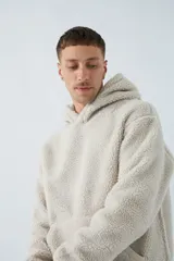 Canguro marrón de sherpa polar con capucha, bolsillo tipo canguro y logo de goma en la manga.
