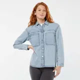 Sobrecamisa de denim celeste con cuello clásico, cierre frontal con botones a presión, mangas largas con puños abotonados, dos bolsillos de parche en el pecho y corte holgado.