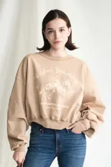 Sudadera color camel con estampado desgastado de Waylon Jennings montando a caballo, con texto que incluye "Littlefield Texas". Presenta un corte cropped y puños acanalados.