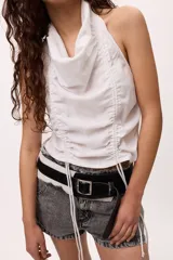 Top blanco sin mangas con cuello halter y frunces ajustables en el frente. Confeccionado en algodón y lino.