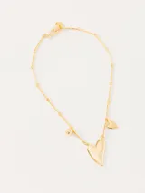 Collar dorado con cadena de eslabones y dijes de corazón, uno grande con un pequeño cristal y otro pequeño liso. Incluye dije de esfera. Cierre con gancho.