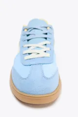 Zapatillas deportivas celestes con detalles en blanco y amarillo.