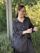 Camisa oversize rosada de lino, con cuello clásico, cierre frontal con botones, dos bolsillos de parche en el pecho y mangas largas con puños abotonados.