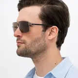 Lentes de sol INVU modelo B1007F, con montura metálica color gris plomo y patillas negras. Lentes polarizados color marrón.