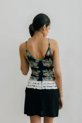 Minifalda color beige con detalle de volados negros en escote, cintura y sisas.