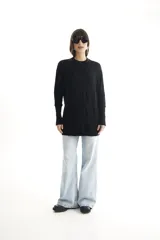 Sweater largo negro de tejido de punto con detalle de trama trenzada en el delantero.