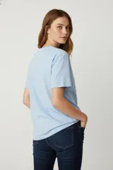 Remera blanca de algodón con estampado de plato con sardinas y texto en color lila.