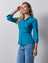 Camisa blanca de algodón marca Zac & Rachel, con cuello con solapa, abertura central con botones, delantera tableada y laterales elastizados.