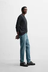 Pantalón de jean azul oscuro, corte slim fit, tiro medio, cinco bolsillos, tejido elástico y efecto lavado.