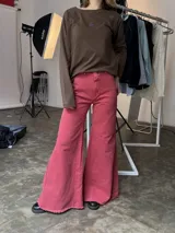 Pantalón jean fucsia de tiro medio, corte wide leg con godets y ruedo desflecado.